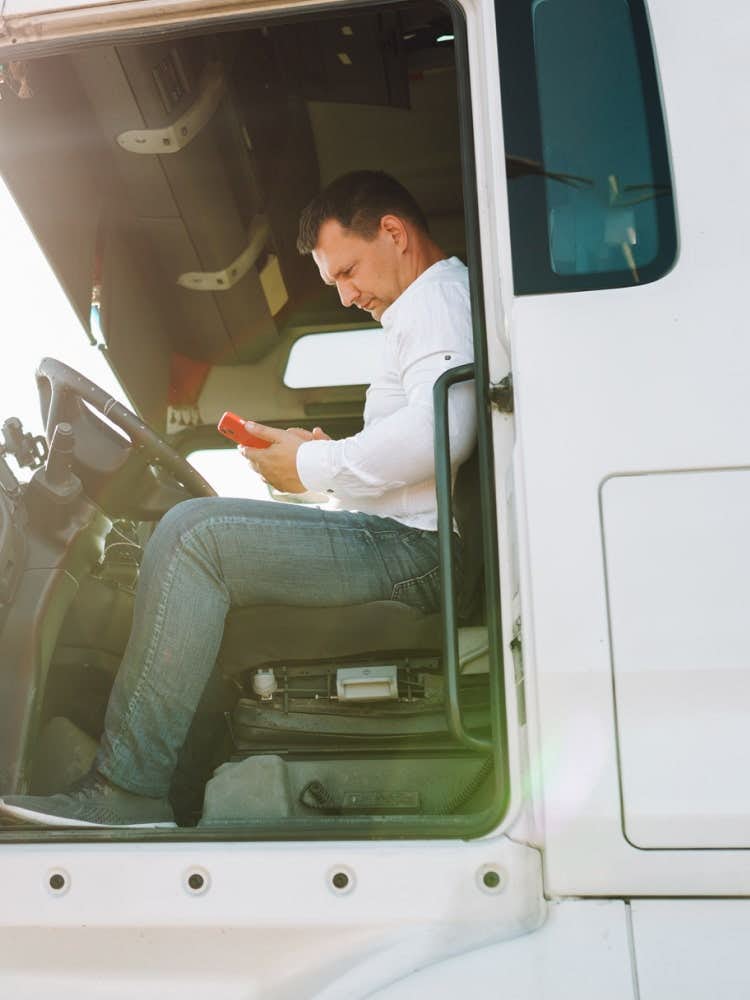 trucker using phone in truck